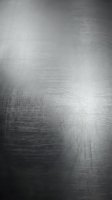 Brushed metal surface with fine linear texture and reflective finish for industrial design backgrounds and modern architectural elements.