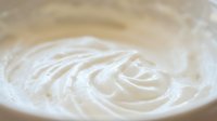 Creamy white swirl texture with smooth flowing patterns creating elegant spiral motion for culinary and beauty applications.