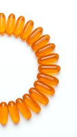 Orange omega-3 fish oil capsules arranged in curved line on white background. Dietary supplements for health and wellness nutrition isolated.