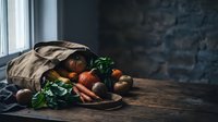 Fresh organic vegetables spilling from burlap sack on rustic wooden table near window. Farm-to-table concept for healthy eating and sustainable living.