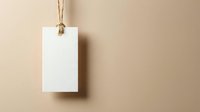 Blank white paper tag hanging on natural twine rope against beige background for branding, pricing, labeling and retail merchandise display.