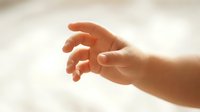 Newborn baby hand reaching out, isolated on white background, suitable for parenting, healthcare, and family design projects.