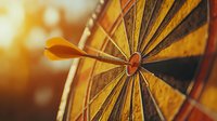 Orange dart arrow hitting bullseye target on classic dartboard, close-up macro shot with selective focus and warm lighting, showing precision and accuracy in business.