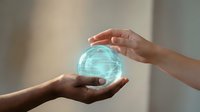 Young adult hands of mixed ethnicity holding a glowing digital fingerprint sphere, representing biometric security, identity verification, and technology innovation for cybersecurity applications.