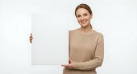 Young Caucasian businesswoman in beige sweater holding blank white poster board with confident smile isolated on white background for presentations.