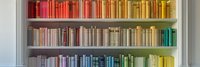 Colorful rainbow bookshelf arrangement showing books organized by color spectrum from red to blue, creating an aesthetic ombre effect in modern interior design.