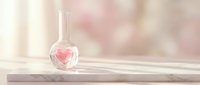 Clear glass perfume bottle with pink fragrance on marble surface against soft blurred background for luxury cosmetics and beauty product advertising.