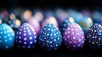 Decorated Easter eggs in blue and purple colors with polka dot pattern on dark background with soft bokeh lights creating festive holiday atmosphere.