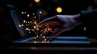 Female hand touching laptop keyboard with magical glowing sparkles in dark room, creating ethereal atmosphere with bokeh light effects and digital transformation concept.