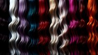 Colorful hair extensions and wigs display showcasing vibrant rainbow colors from blonde to pink, purple, blue and red in wavy textures for beauty salon use.