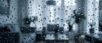 Raindrops cover window glass with blurred cityscape and buildings in background, conveying rainy weather, urban atmosphere, and moody ambiance for design projects.