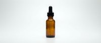 Amber glass dropper bottle with black pipette cap on white background, suitable for essential oils, serums, tinctures, and cosmetic product packaging.