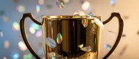 Golden trophy cup with confetti celebration background for achievement recognition and success awards ceremony.