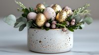 Luxurious Easter arrangement with gold speckled eggs and eucalyptus in modern white ceramic bowl with gold splatter pattern, elegant holiday decor styling.