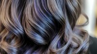 Close-up of lustrous wavy hair with multi-tonal highlights showcasing professional salon coloring technique and healthy shine for beauty and haircare concepts.
