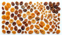 Assorted dried apricots and dates arranged on white background, isolated for culinary, food styling, nutrition and healthy eating design projects.