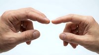 Two hands reaching toward each other with fingers almost touching, symbolizing connection, unity, and human interaction on white background.