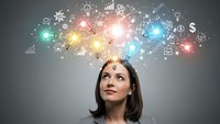 Young businesswoman looking up at colorful glowing innovation icons representing creative thinking, technology solutions and entrepreneurial mindset.