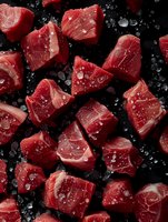 Fresh raw tuna chunks with water drops on black background, close up view of red fish pieces with marbling texture for seafood restaurant menu design.