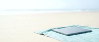 Tablet and smartphone on light blue fabric against neutral beige background, minimalist workspace setup for technology, business, and digital design projects.