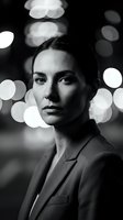 Professional businesswoman portrait in black and white with bokeh city lights background for corporate branding and marketing materials.