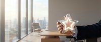 Businessman hand holding glowing star icon in modern office space representing excellence, quality rating, customer satisfaction and business success achievement.