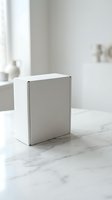 White cardboard box on marble surface in bright minimalist interior for product packaging and branding mockup presentations.