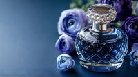 Elegant crystal perfume bottle with ornate silver cap surrounded by purple roses on blue background for luxury beauty and fragrance concepts.