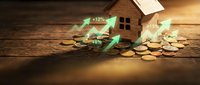 Wooden house model with rising arrow graphics and coins on rustic table representing real estate investment growth and property value increase concept.