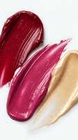 Three glossy lipstick smears in deep red, magenta pink, and shimmery gold on white background, showcasing luxury cosmetic textures for beauty branding.