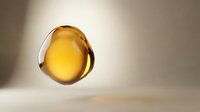 Golden oil droplet suspended in air against neutral background, suitable for cosmetics, skincare, wellness and beauty product marketing materials.