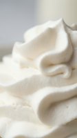 Creamy white whipped cream swirls with soft texture and delicate folds creating luxurious dessert topping for culinary and food photography applications.