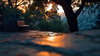 Atmospheric sunset scene with wooden bench under tree silhouette, golden light reflecting on wet cobblestone path creating magical evening ambiance in park setting.