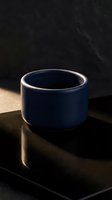 Modern navy blue ceramic bowl on dark surface with dramatic lighting and shadows for contemporary kitchen design.