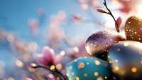 Festive Easter eggs decorated with polka dots and spring blossoms against blurred blue background with magical bokeh lights and soft pink flowers.