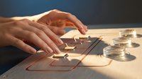 Young adult hands arranging tarot cards on wooden surface with glass jars, mystical divination practice and fortune telling ritual setup.