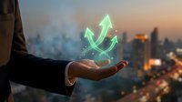 Business professional holding glowing green growth arrows above palm against city skyline at sunset representing success and financial progress.