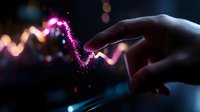 Magical glowing pink light trail following finger movement in dark space, creating ethereal wave pattern with sparkles and bokeh effect in background.