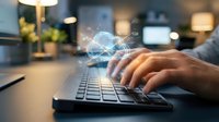 Hands typing on laptop keyboard with glowing digital brain hologram representing artificial intelligence and machine learning technology in modern office.