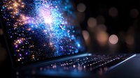 Laptop keyboard illuminated by magical cosmic light effect with sparkles and blue purple glowing particles against dark background.