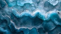 Abstract aerial view of turquoise and white wavy patterns on dark background creating natural marble texture with flowing lines and organic shapes.