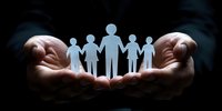 Caring hands holding paper cutout family silhouettes against dark background, representing family protection, unity, support and social services concept.