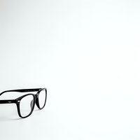 Black-framed eyeglasses on clean white background with copy space for optical shop advertising and vision care marketing materials.