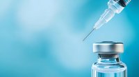 Medical syringe with needle and glass vial containing vaccine or medicine on blue gradient background with copy space for healthcare concept.
