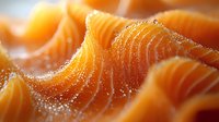 Fresh raw salmon fillet with visible fat lines and glistening texture, macro close-up showing the vibrant orange color and natural oils of premium seafood.