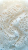 Creamy white soap foam with bubbles creating luxurious lather texture for skincare and beauty product backgrounds.