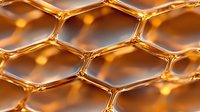 Macro view of golden honeycomb structure with hexagonal cells creating geometric pattern. Natural honey texture with amber glow and reflective surface.
