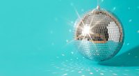 Shiny disco ball with sparkling light reflections on turquoise background for party celebration entertainment music dance club nightlife events.