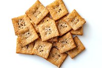 Golden crispy crackers with seeds scattered on white background, isolated snack food for healthy eating and appetizer concepts.