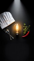 Chef hat with glowing lightbulb, utensils, herbs and chili pepper on dark background representing culinary creativity and cooking inspiration.